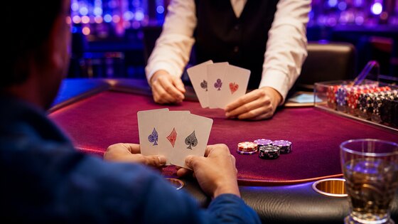Kolme kaardiga Teen Patti laua vastaskülgedel mängija ja diileri käed.
